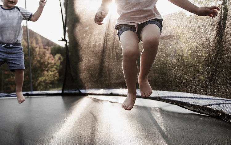 Two children jumping on a trampoline