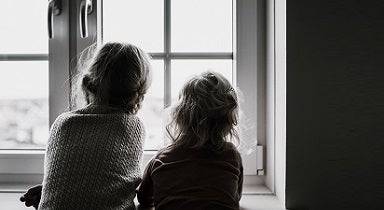 Kids sitting by a window symbolising the importance of protecting your family from fraud and scams