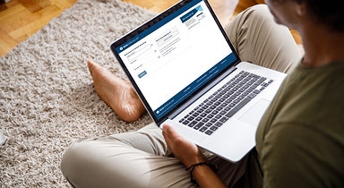 Person on a PC checking the warning signs of fraud and scams